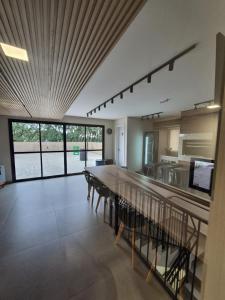 a large kitchen and dining room with a long table at Studio Novo e completo perto da PUC in Curitiba