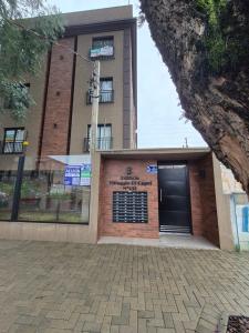 a building with a garage with a black door at Studio Novo e completo perto da PUC in Curitiba +18 photos