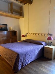 a bedroom with a bed with a purple bedspread at Apartment in ancient historic villa near Florence in Rufina