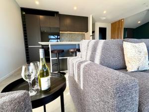 a bottle of wine sitting on a table next to a couch at OHAU I Love 15 in Twizel