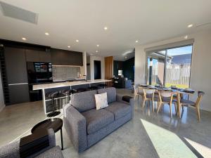 a living room with a couch and a table with chairs at OHAU I Love 15 in Twizel