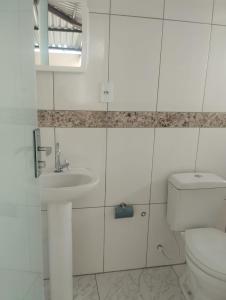 サンタ・クルース・デ・ミナスにあるCasa para temporadaのトイレと洗面台を備えた白いバスルーム
