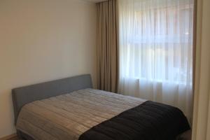 a bed in a bedroom with a window at Baltic Apartments Premium in Palanga