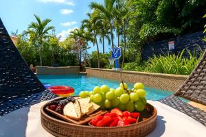 a bowl of fruit on a table next to a pool at Avatar Miami Villa - Heated Pool & Spa - Pickleball & Cinema in Hammocks