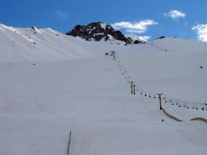 a snow covered slope with a mountain in the background at Los penitentes, edificio juncal dpto 1 in Los Penitentes