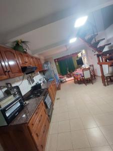 cocina con armarios de madera y sala de estar. en Casa Libertad, en Chumillo 5 fotos más