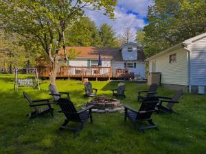 a group of chairs around a fire pit in a yard at Cozy Pocono Home with a Hot Tub, Fire pit, Games and more! in Albrightsville