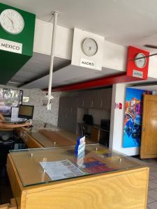 an office with clocks on the wall and a desk at Hotel Italia, Aguascalientes in Aguascalientes