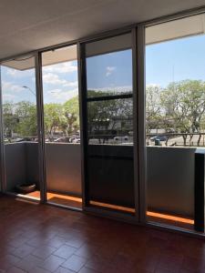 an empty room with glass doors in a building at Hotel Italia, Aguascalientes in Aguascalientes