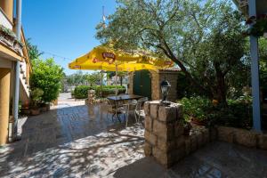 a patio with a table and a yellow umbrella at Apartments with parking space Vrsi - Mulo, Zadar - 3276 in Vrsi