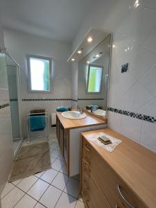 a bathroom with a sink and a mirror at Villa du Bonheur Carambole in Saint-Georges-dʼOléron