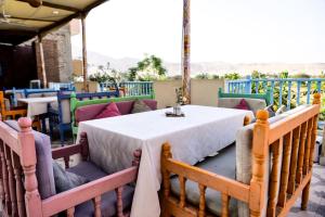 a table and chairs in a restaurant with a view at Flamingo Memnon Guest House in Luxor