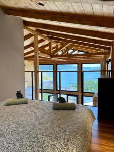 a bedroom with a large bed with a large window at Mount Log Cabins in Mavrovo