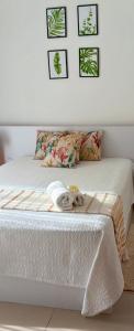 una camera da letto con un letto con lenzuola bianche e quadri appesi al muro di 3bed villa with private pool and rooftop with a sea view in flic-en-flac, Mauritius a Flic-en-Flac
