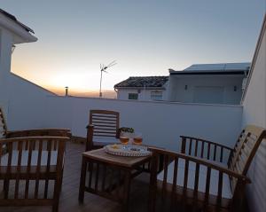a balcony with a table and chairs and a sunset at Casa Papel y Pluma in Cazorla