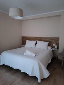 a white bedroom with a large bed with white sheets at Casa Papel y Pluma in Cazorla +9 photos