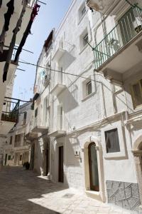 een groot wit gebouw met balkons in een straat bij Casa Perugini in Monopoli