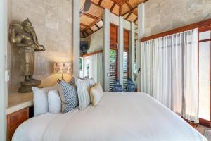 a bedroom with a large white bed and a window at Far Pavilions - An Intimate Bali-style Haven in Port Douglas +30 photos