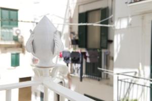 een witte leuning met een witte stoel op een balkon bij Casa Perugini in Monopoli