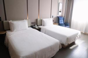 a hotel room with two beds and a blue chair at Atour Hotel Shanghai Xianxia in Shanghai +29 photos