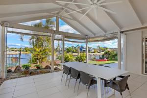Un comedor blanco con una mesa y sillas. en Large Waterfront Home With Pool, en Mooloolaba