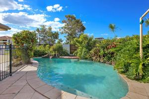 una piscina en un patio con valla en Large Waterfront Home With Pool, en Mooloolaba
