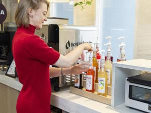a woman is putting drinks in a drink cooler at Tokyu Stay Yotsuya - Shinjuku Area in Tokyo