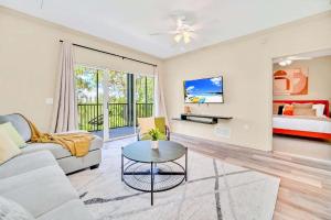 una sala de estar con un sofá y una mesa en Modern 2BR Condo - Hot Tub and Pool - Near Disney, en Orlando