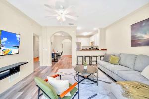 una sala de estar con un sofá y una mesa en Modern 2BR Condo - Hot Tub and Pool - Near Disney, en Orlando