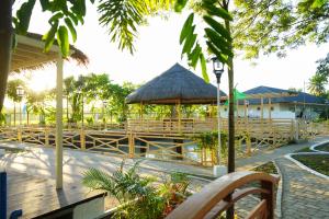 a restaurant with wooden benches and a pavilion at The Ylang Ylang Events Place in Mangatarem