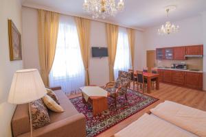 a living room with a couch and a dining room at Apartments Paderewski in Karlovy Vary