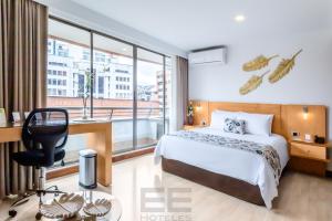 um quarto de hotel com uma cama, uma secretária e uma janela em Leblón Suites Hotel em Medellín