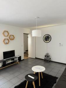 Una sala de estar con dos taburetes y una mesa. en House Mendoza - Apartamento de 2 plantas, en Mendoza