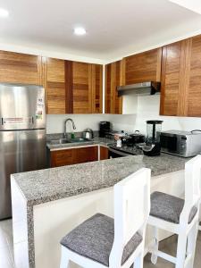 a kitchen with a granite counter top and wooden cabinets at Villa Mariposa\Modern&Lux\ Swimming Pool in Muñoz