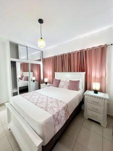 a bedroom with a large white bed with pink curtains at Villa Mariposa\Modern&Lux\ Swimming Pool in Muñoz +20 photos