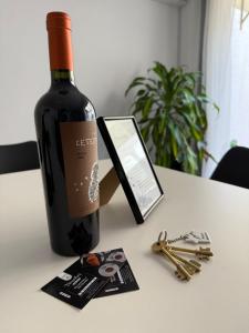 Una botella de vino sobre una mesa con llaves. en House Mendoza - Apartamento de 2 plantas, en Mendoza