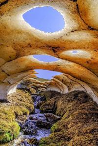 a view of a river through a rock formation at El cortijo azul in Güéjar-Sierra