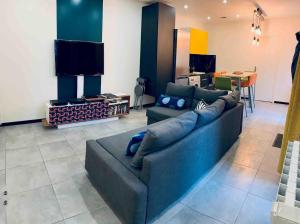 a living room with a couch and a tv at Contemporary house stadium of france in Saint-Denis