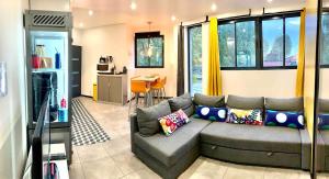 a living room with a couch and a kitchen at Contemporary house stadium of france in Saint-Denis