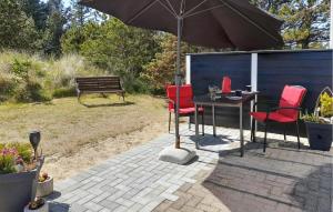 a patio with a table and chairs and an umbrella at Holiday Home Grårisvej Thisted V in Nørre Vorupør +7 photos