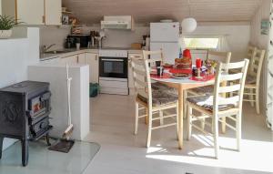 a kitchen with a table and chairs and a stove at Holiday Home Grårisvej Thisted V in Nørre Vorupør