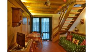 a living room with a green couch and stairs at Cristallo & Faloria Suite Apartments in Cortina dʼAmpezzo