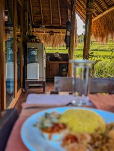 a plate of food on a table in a restaurant at Cute Eco Cottage Near 7 Waterfalls in Singaraja