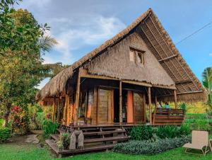 a small house with a thatched roof at Cute Eco Cottage Near 7 Waterfalls in Singaraja