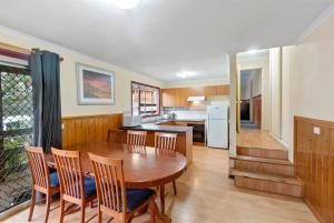 Una cocina con una mesa y sillas de madera. en Rosella Views, en Mount Buller