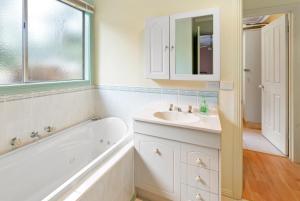 Un baño blanco con bañera y lavabo. en Rosella Views, en Mount Buller 5 fotos más