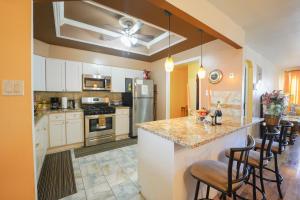 a kitchen with white cabinets and a island with bar stools at Chekells Cozy stay close to everything Free WIFI in Brooklyn