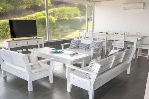 プンタ・デル・エステにあるSierra Ballena 2のダイニングルーム(白いテーブル、椅子、テレビ付)