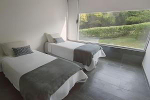 プンタ・デル・エステにあるSierra Ballena 2の大きな窓のある部屋にベッドが2つある +33枚の写真