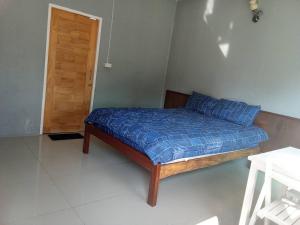 a bedroom with a bed with a blue comforter at boomhousehotel in Chiang Khong